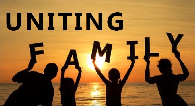 Silhoutte image of a family at the beach at sunset holding up the words family