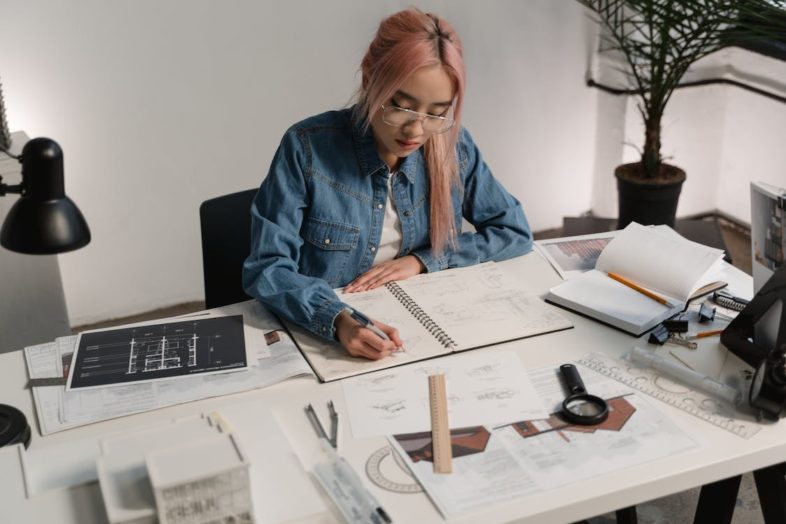 Woman with pink hair working at desk