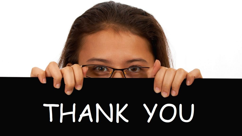 Women holds up a Thank You sign to express gratitude