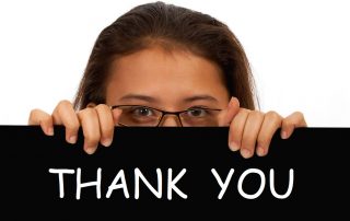 Women holds up a Thank You sign to express gratitude